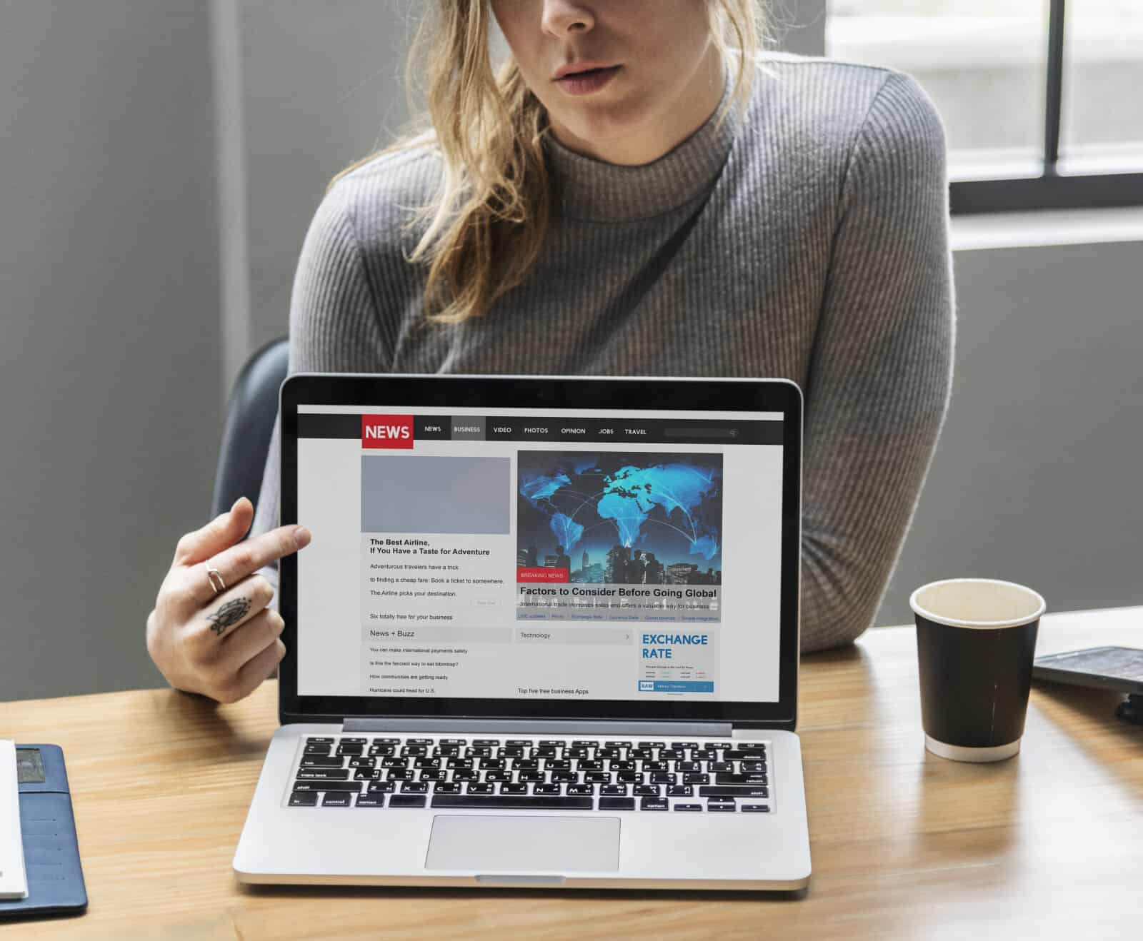 A woman is sitting at a desk with a laptop.