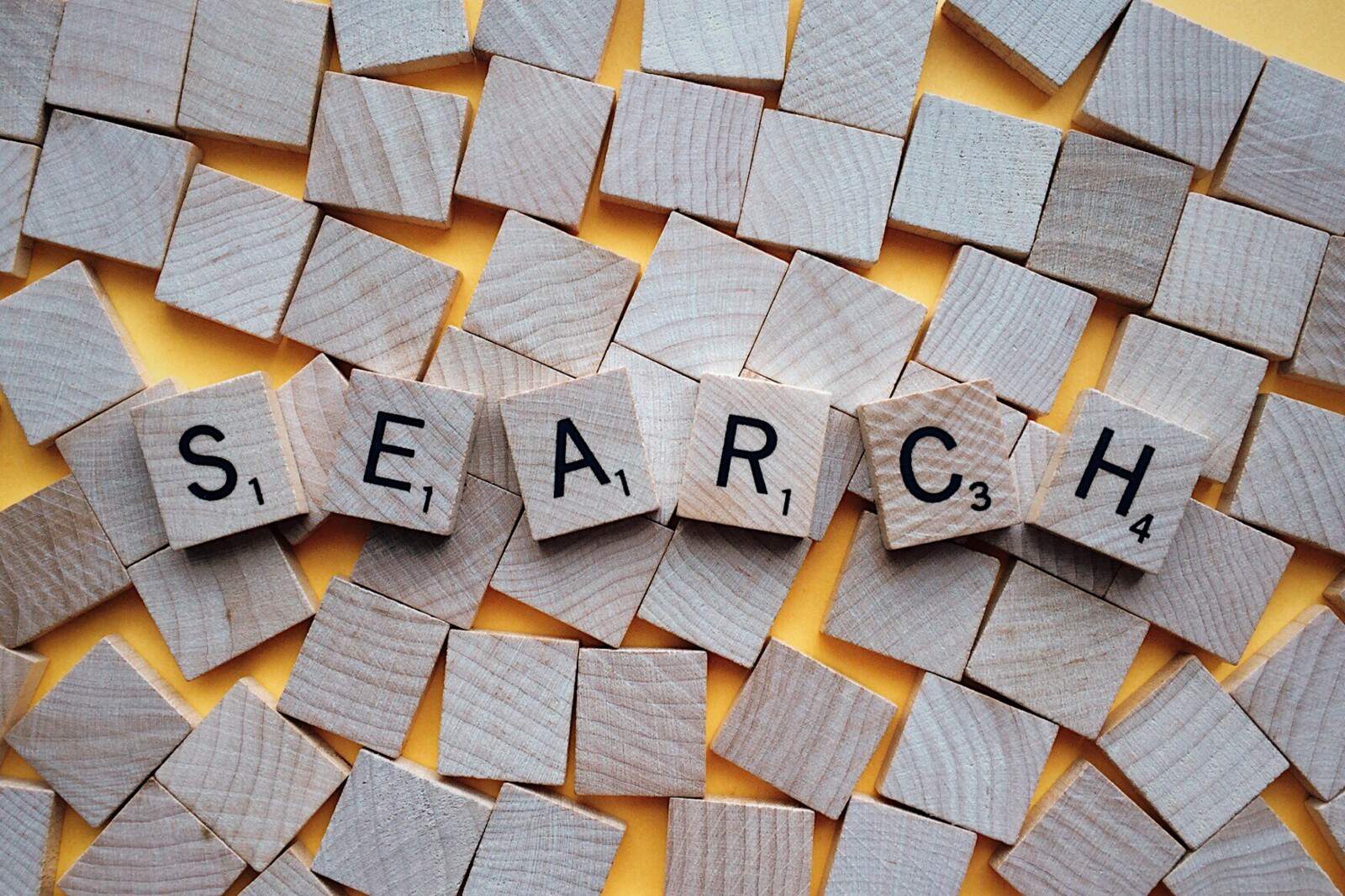 The word search spelled out in wooden blocks on a yellow background.